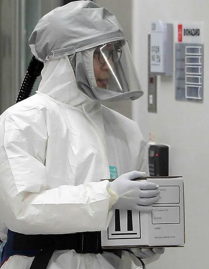 韩国清州某疾病管理中心实验室的医疗人员穿着防护服预演埃博拉病毒的检查和处理过程